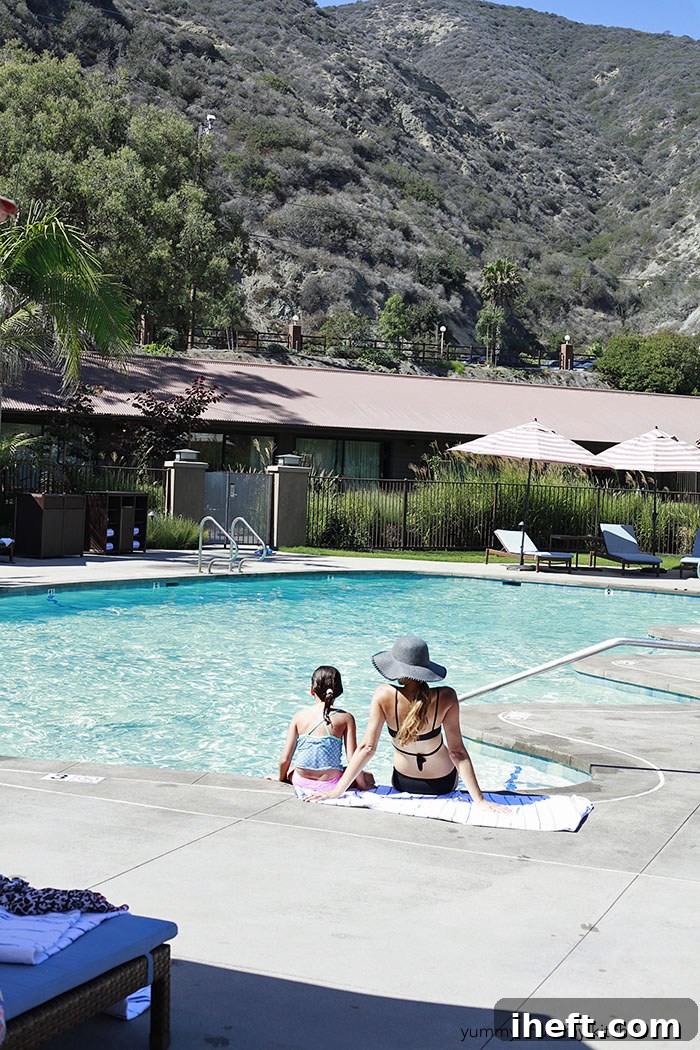 Serene pool area at The Ranch at Laguna Beach, surrounded by lush landscaping and comfortable loungers, ideal for relaxation.