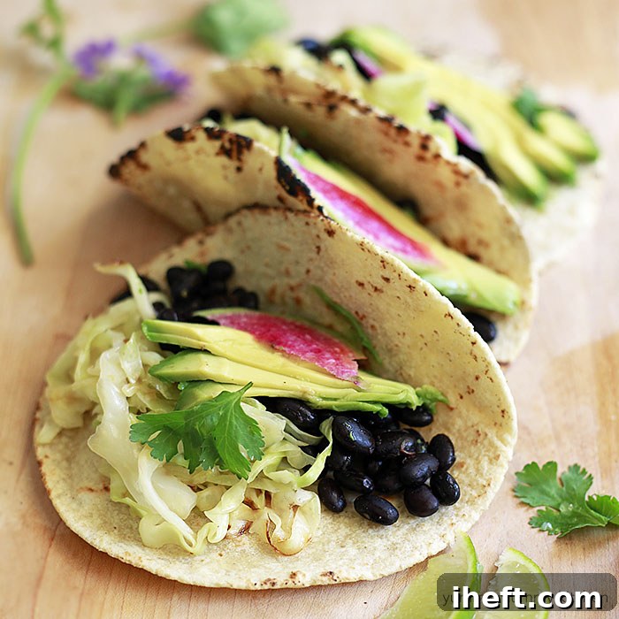Mouth-watering vegan tacos with black beans, tender cabbage, avocado, and radish ready to be enjoyed