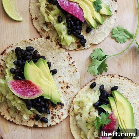 Beautiful vegan tacos with black beans, cabbage, and avocado ready to be served