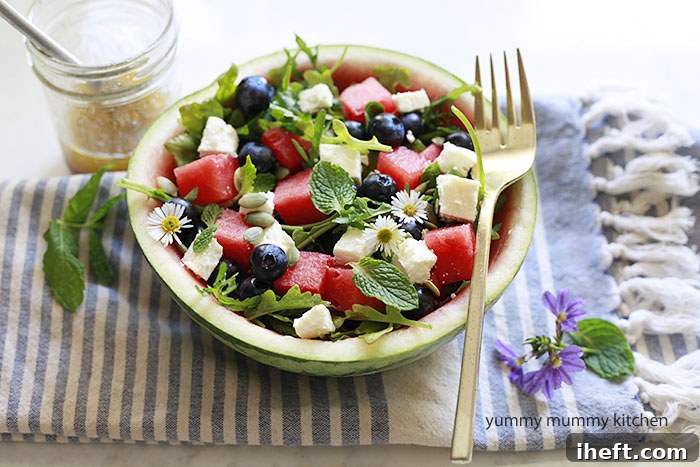 Vibrant Watermelon Feta Salad with arugula, blueberries, and fresh mint, beautifully presented in a watermelon bowl