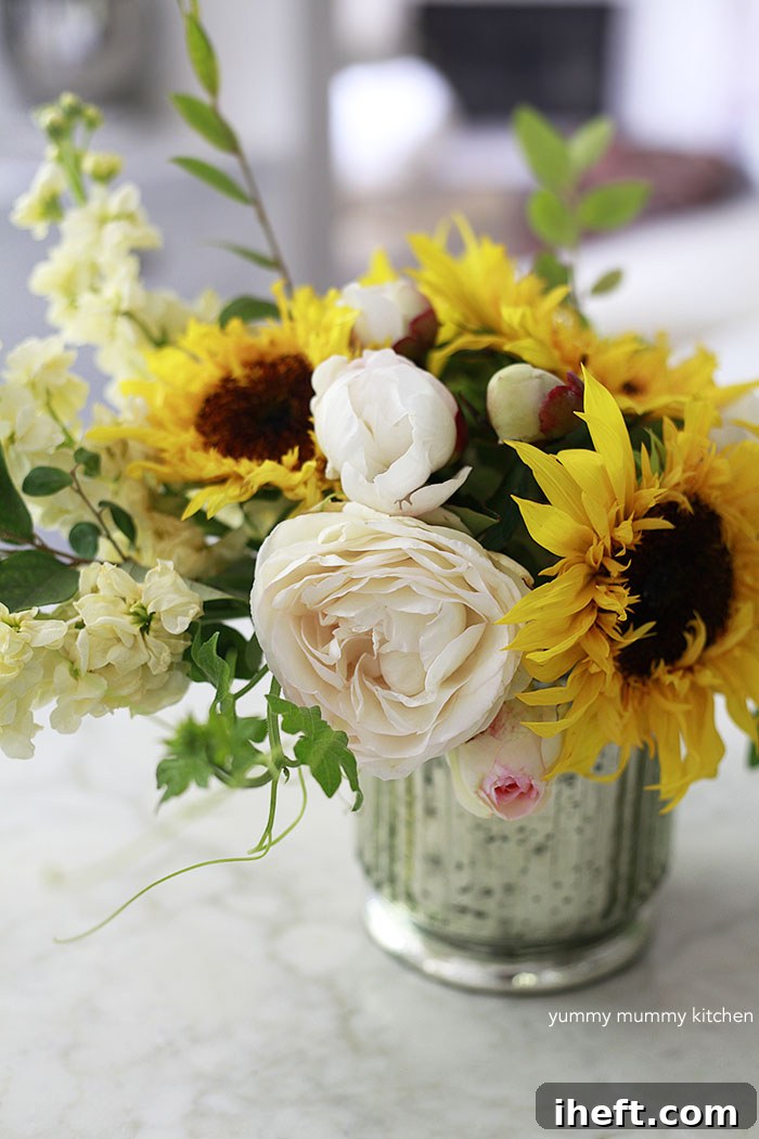 Flower arrangement with sunflowers, peonies, and greenery