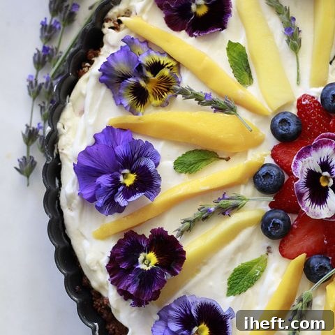 Beautiful breakfast tart with yogurt, fruit, and edible flowers.