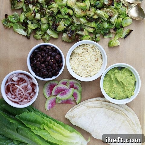 A vibrant platter of roasted Brussels sprouts and various toppings, ready for making delicious tacos.