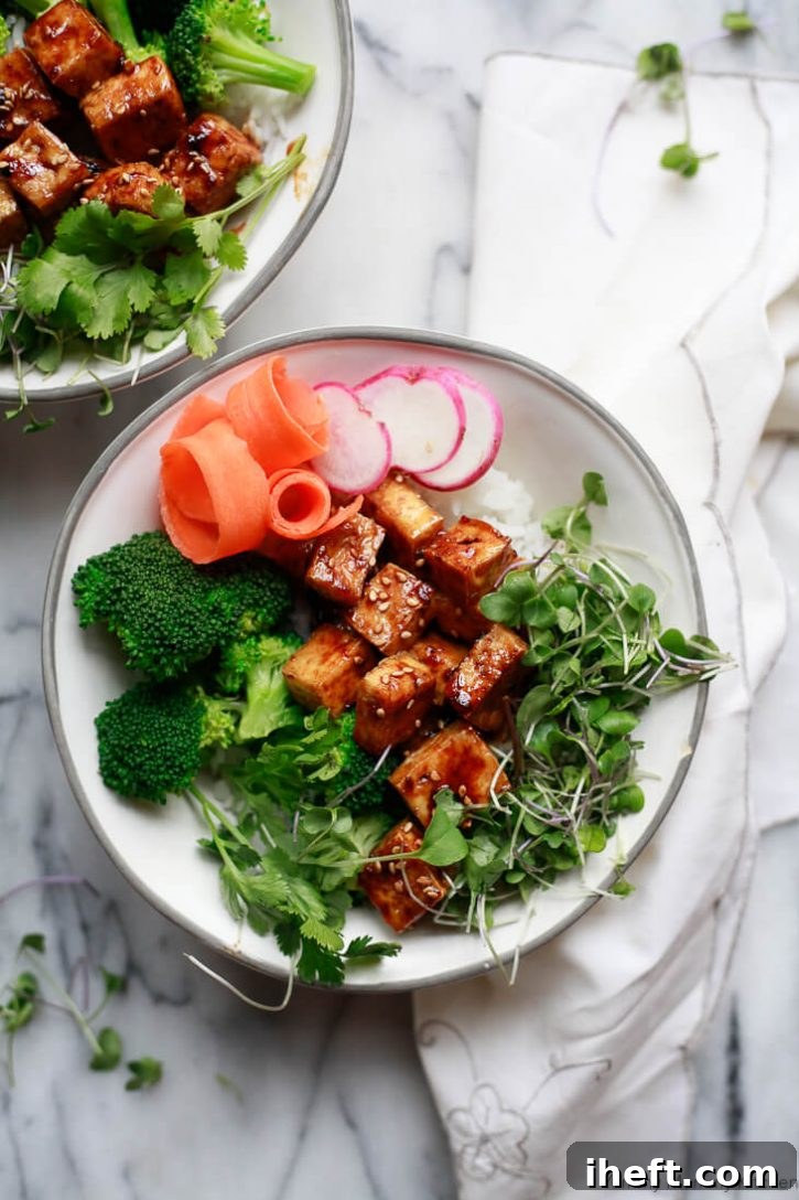 Crispy Baked Tofu with Ginger Soy Glaze, served in a Buddha bowl with fresh vegetables and grains.