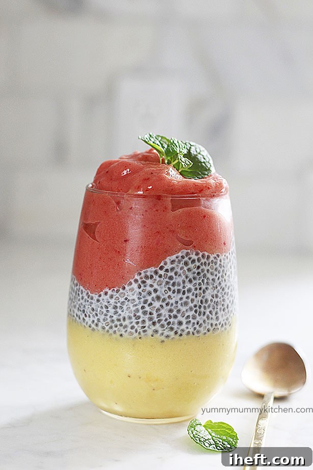 A glass of tropical smoothie with chia pudding layered in the middle. 