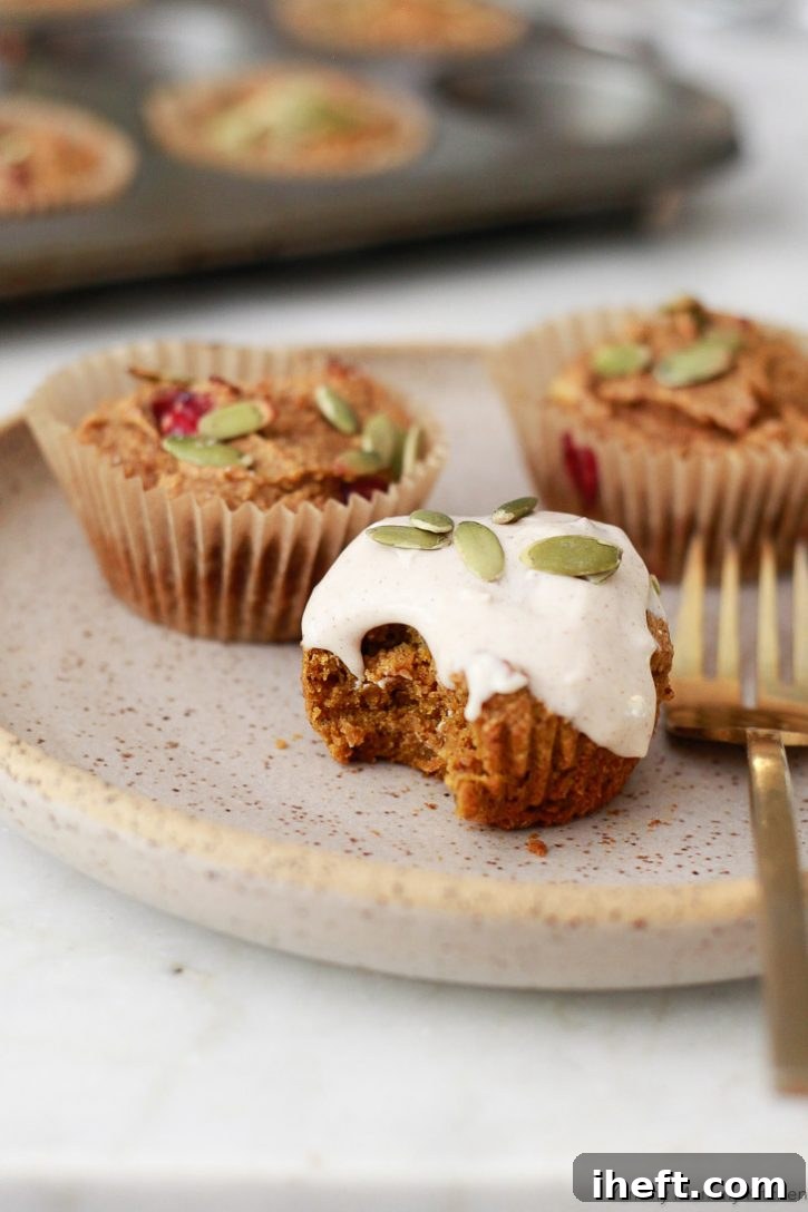 Beautiful vegan gluten-free pumpkin muffins with cinnamon cream cheese frosting and pepitas.