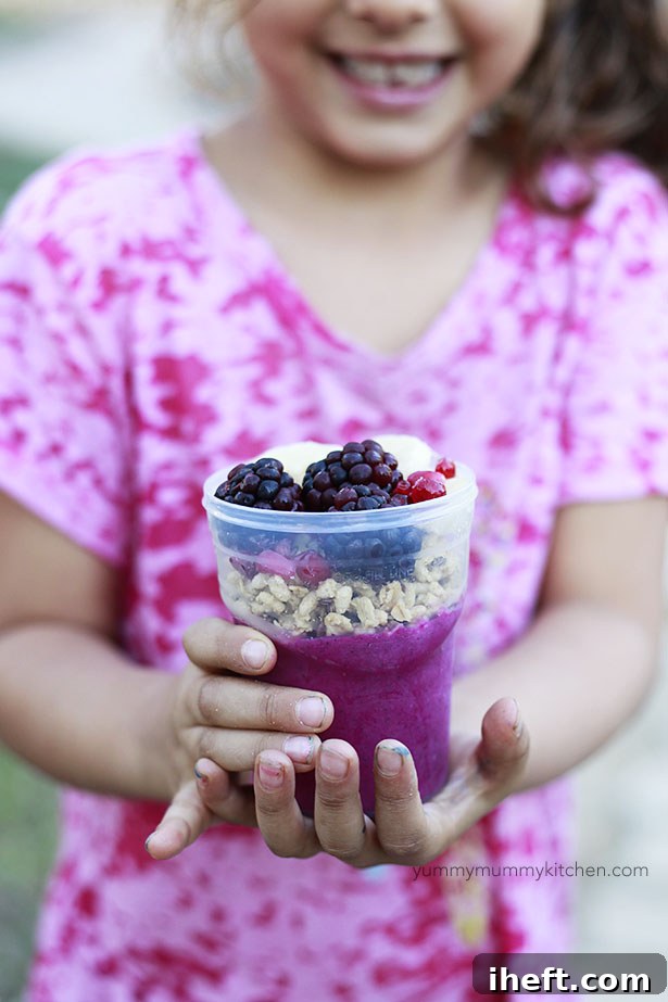 Colorful acai bowl topped with granola and berries, ready for freezing.