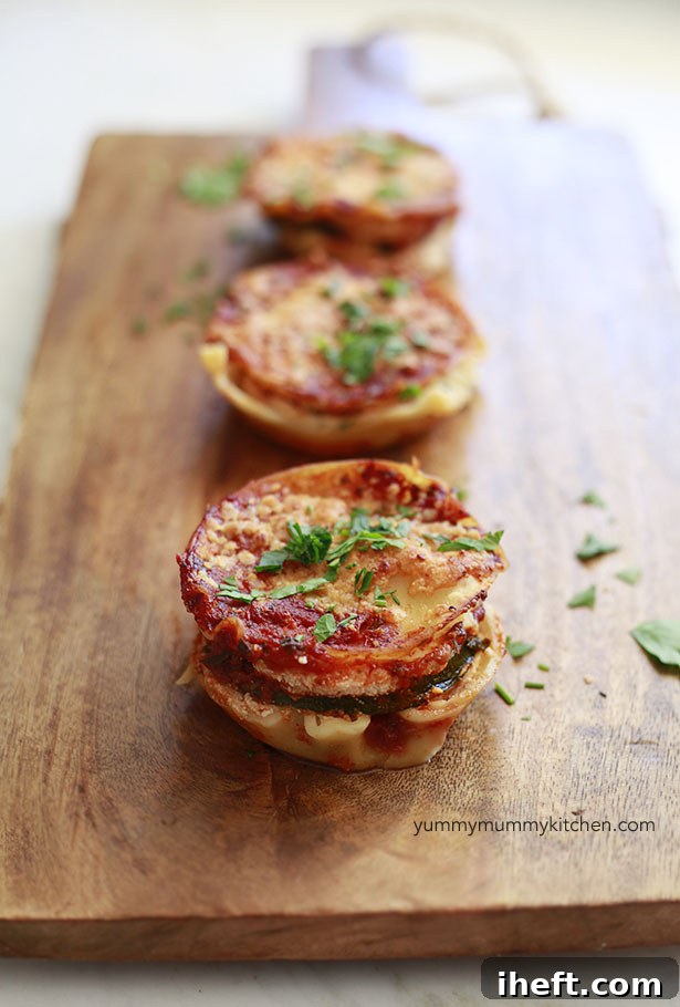 Delicious mini vegetarian lasagna cupcakes on a wooden cutting board, ready to serve.