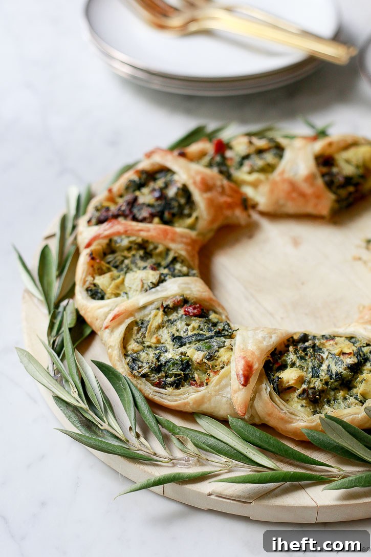 A freshly baked, golden brown spinach artichoke puff pastry wreath