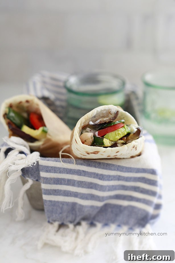 Two vegetarian gyros with colorful grilled vegetables and chickpeas neatly arranged in a rustic basket, ready to be enjoyed.