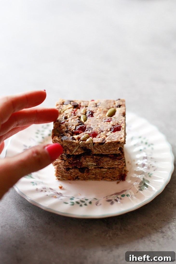These easy no-bake granola energy bars are incredibly delicious, made with wholesome ingredients like gluten-free oats, peanut butter, cranberries, pumpkin seeds, and flax meal, making them an ideal vegan snack.