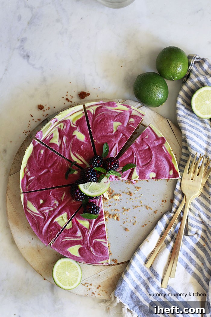 A slice of beautiful raw vegan raspberry cheesecake with natural layers, garnished with fresh raspberries.