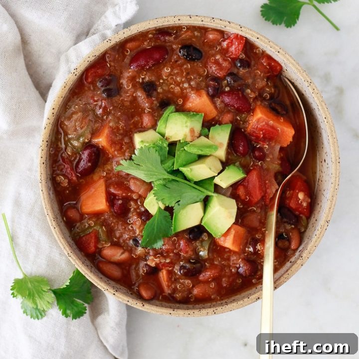Instant Pot Vegetarian Chili with beans, quinoa, and sweet potato, garnished with fresh cilantro and avocado.