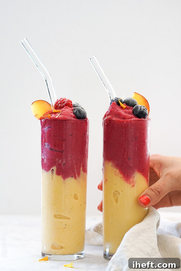 A vibrant peach smoothie in a glass with fresh peaches.