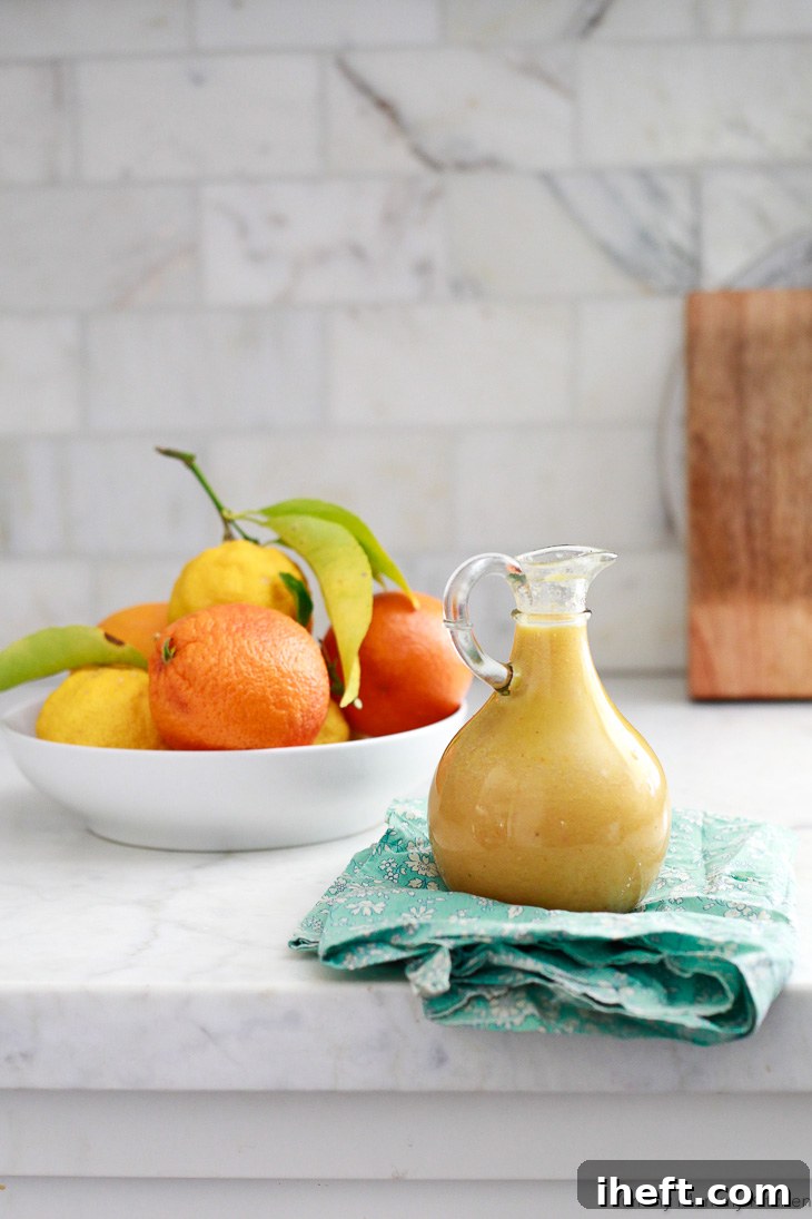 A close-up shot of fresh, light, and tangy homemade orange vinaigrette dressing, perfectly emulsified in a blender. This vibrant citrus dressing is an ideal choice for enhancing any green salad with its bright flavor profile.