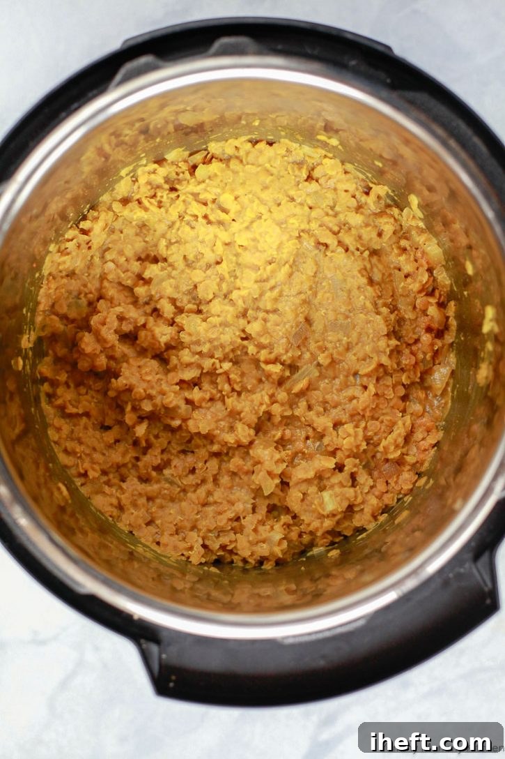 A close-up shot of perfectly cooked red lentil masoor dal resting inside an Instant Pot pressure cooker, ready to be served.