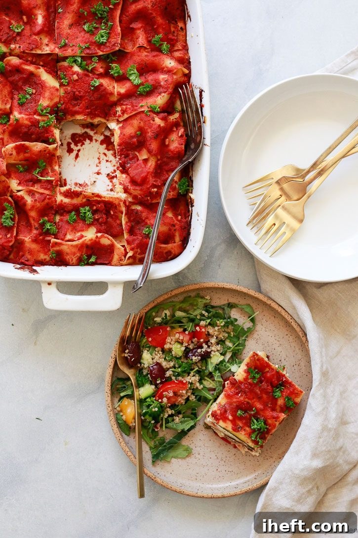 A glorious vegan lasagna in a ceramic baking dish, with a perfect slice removed and placed on a plate. This delightful vegan lasagna is made with luscious layers of homemade almond ricotta, tender eggplant, and vibrant vegetables, showcasing its rich texture and inviting golden-brown top.