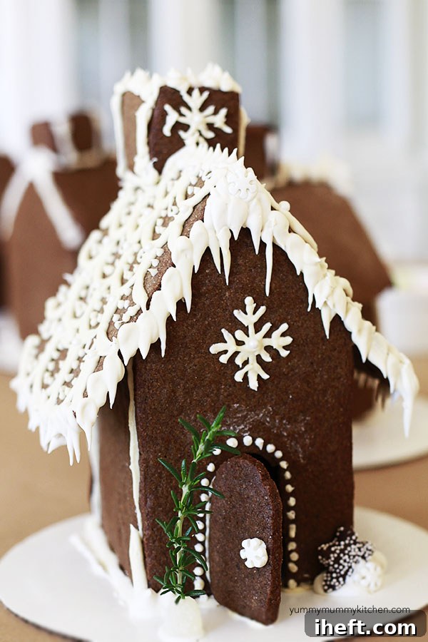 Children happily decorating their gingerbread houses with various candies and icing