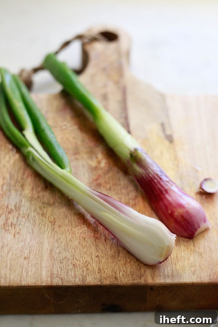 One spring onion sliced in half and ready to cook.