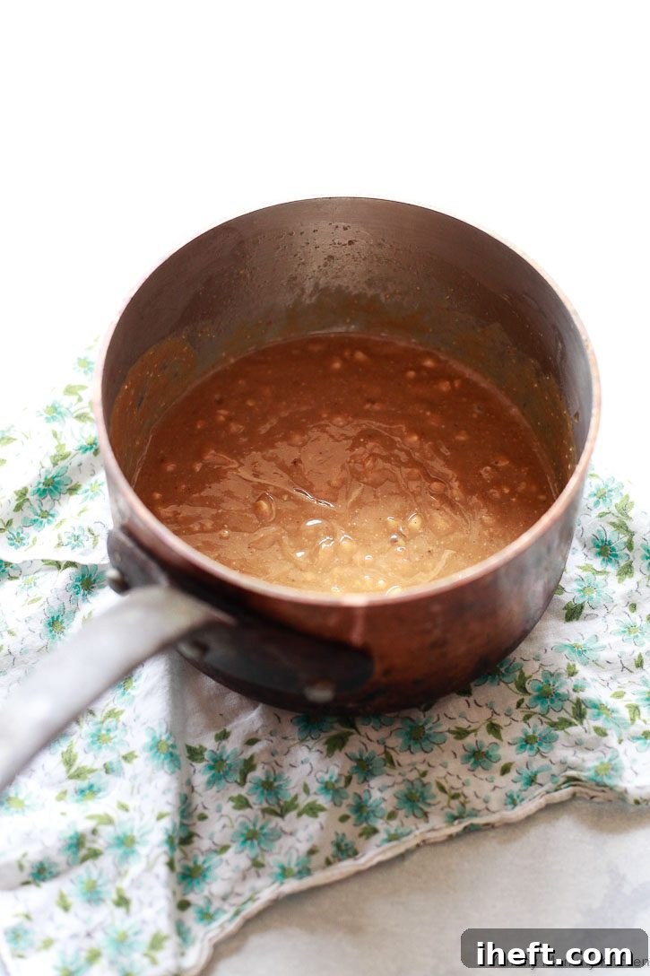 The wet ingredients for no-bake granola bars get melted together in a saucepan. 