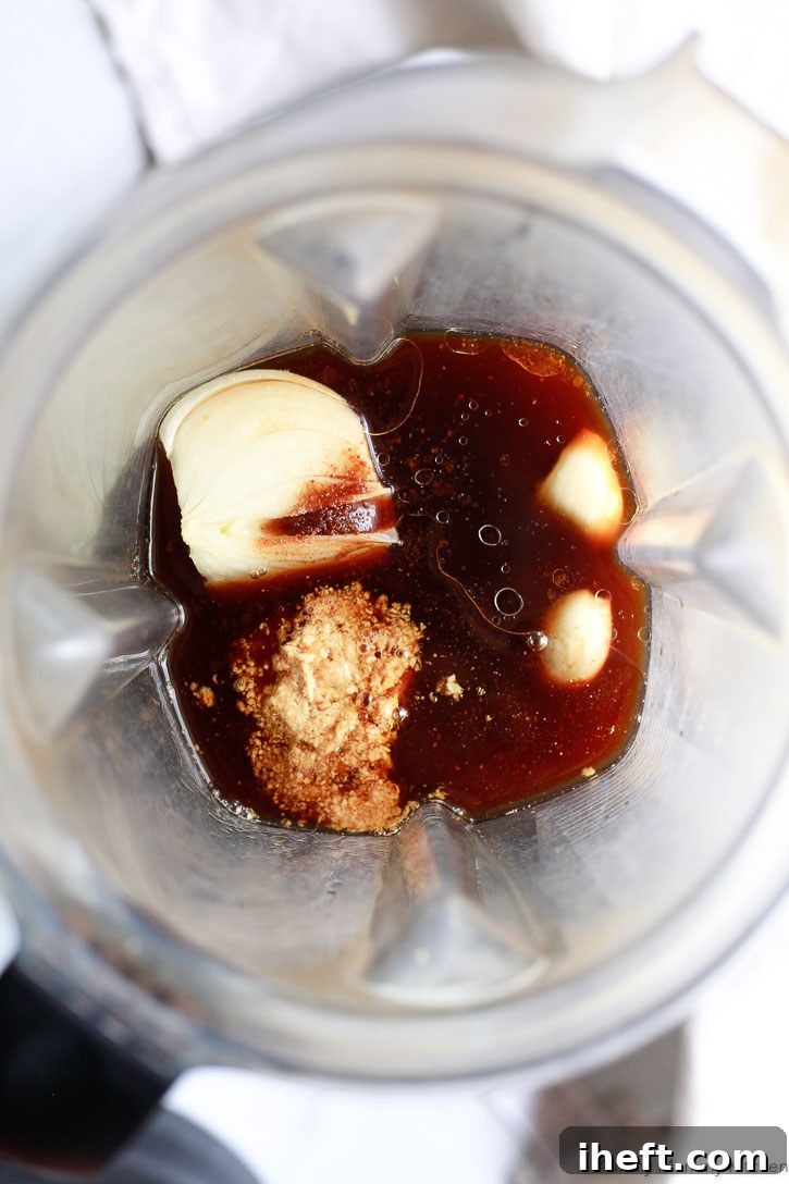 All the fresh ingredients for homemade teriyaki sauce are being expertly placed into a high-powered Vitamix blender, poised to be combined into a smooth, flavorful mixture with minimal effort.