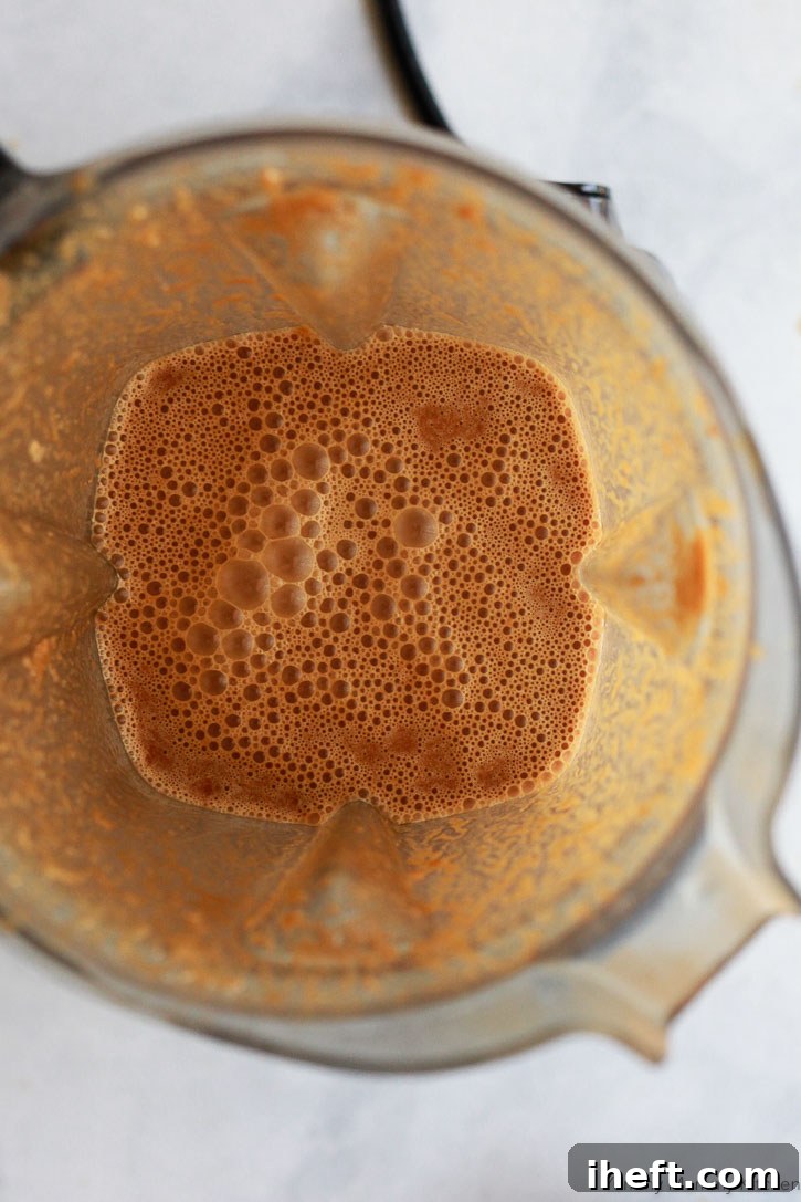 Smooth, perfectly blended homemade teriyaki sauce swirling gracefully inside a Vitamix blender, illustrating the ease of creating this gluten-free and vegan sauce.