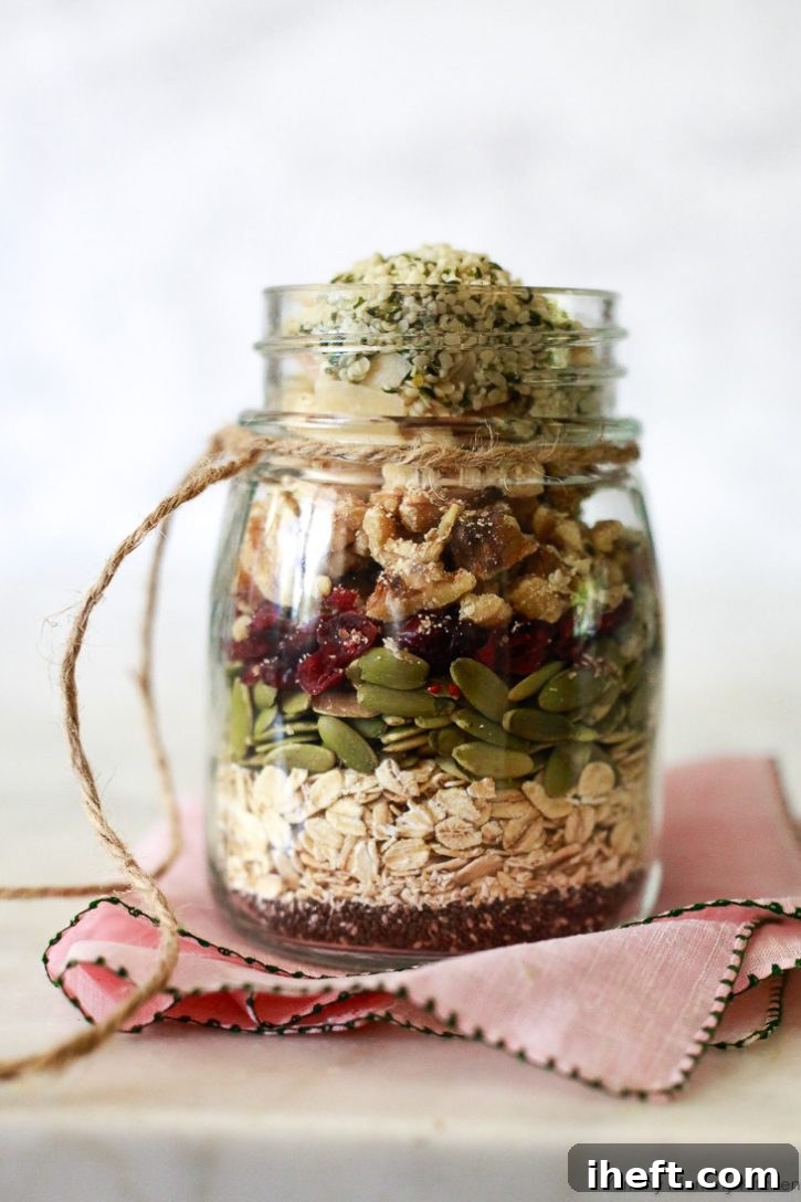 A jar layered with superfood muesli made with oats, chia seeds, pumpkin seeds, cranberries, walnuts, and hemp seeds, ready for soaking or gifting.