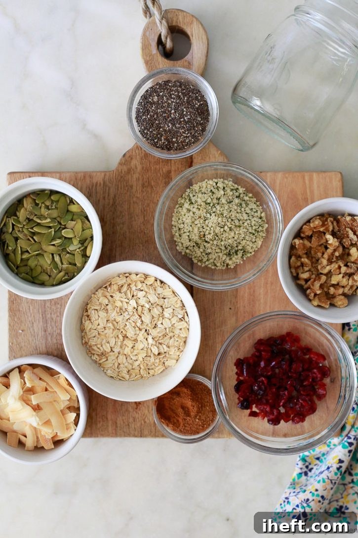 Homemade bircher muesli ingredients laid out on a cutting board, including rolled oats, various seeds, dried fruit, cinnamon, and coconut sugar.