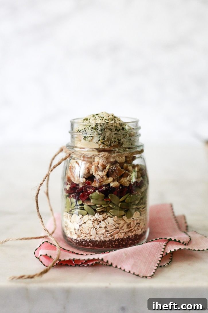 A beautifully layered jar of muesli ingredients like oats, seeds, and dried fruit, perfect as a healthy and creative DIY edible gift idea.