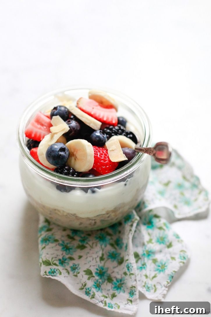 Soaked overnight muesli, perfectly layered in a jar and topped with creamy yogurt, fresh berries, and crunchy coconut chips, for a healthy and convenient vegan grab-and-go breakfast.