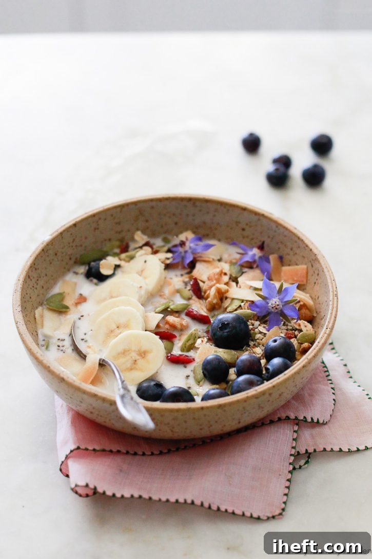A bowl of superfood Bircher muesli with blueberries and almond milk, offering a healthy and refreshing vegan breakfast option.