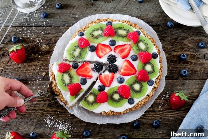 A beautiful array of colorful, healthy fruit pizza slices with a creamy coconut whip topping.