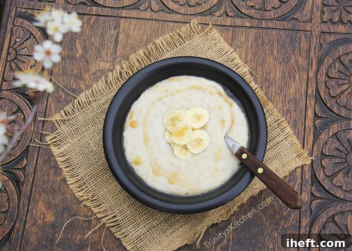 A steaming bowl of creamy coconut banana porridge, a gluten-free vegan breakfast.