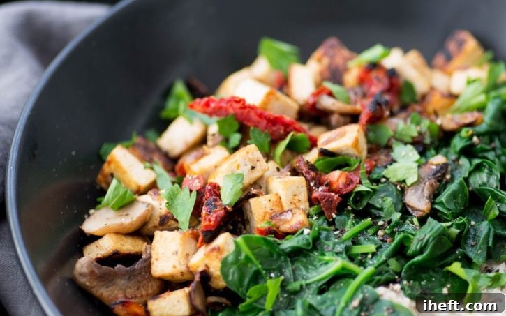 A hearty bowl of savory steel-cut oats with spinach, mushrooms, and tofu, packed with greens.