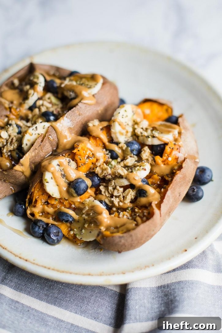 Sweet potatoes topped with granola, almond butter, bananas, and blueberries for a delicious vegan breakfast.