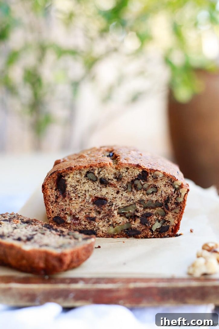 A delicious loaf of oil-free vegan banana bread with walnuts and chocolate chips, reminiscent of a classic.