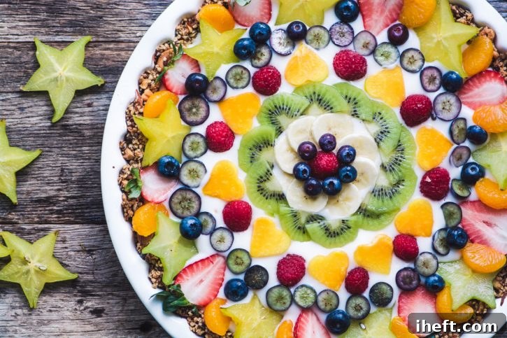 A vibrant and pretty vegan fruit and yogurt breakfast tart, garnished with fresh berries.