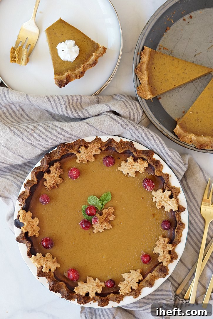 This beautiful vegan and gluten free pumpkin pie is topped with sugared cranberries and pie crust leaves.