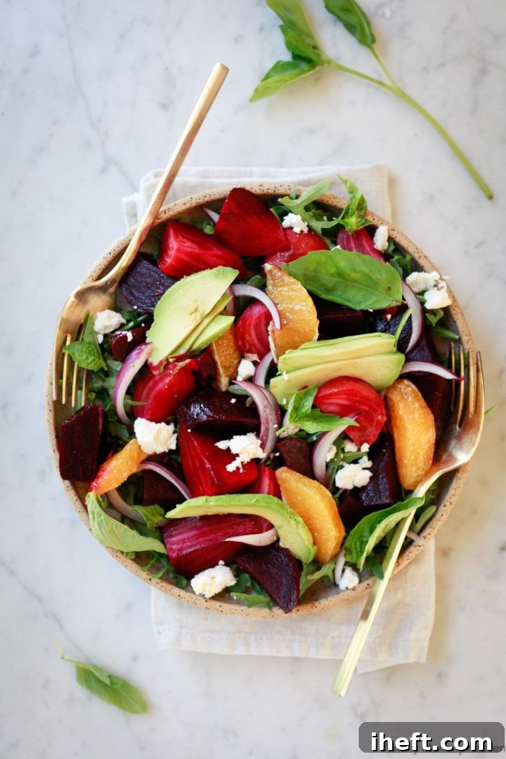 Beautiful roasted beet salad with avocado, orange segments, red onion, basil, and arugula. 