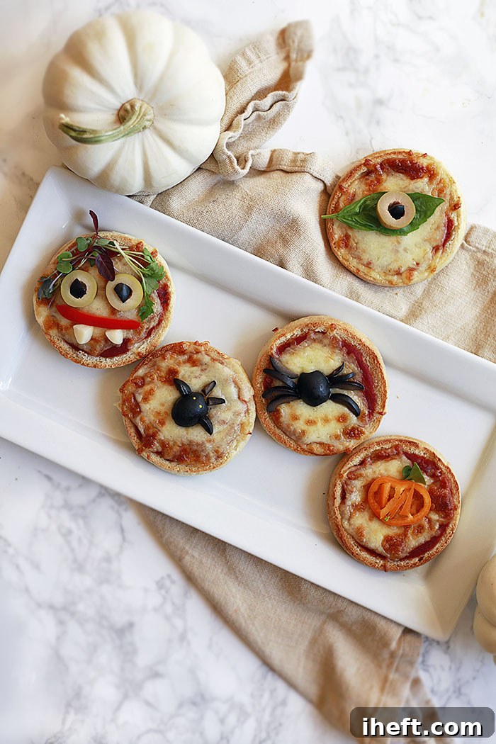 Close-up of a Halloween pizza featuring a detailed spiderweb design made with cheese and sauce, and ghost shapes.