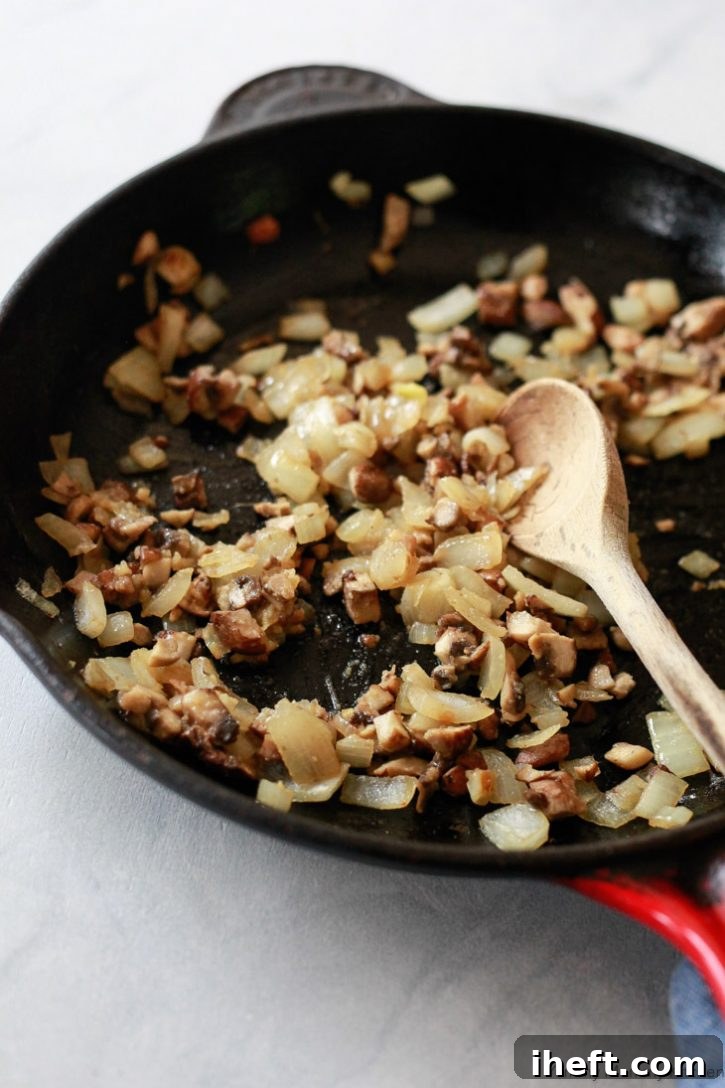 Onions, mushrooms, and garlic get sauteed in a cast iron skillet for vegan lentil meatballs