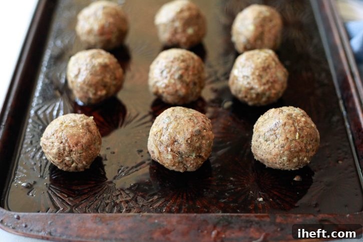 Vegan lentil meatballs on a baking sheet ready to be baked in the oven. 