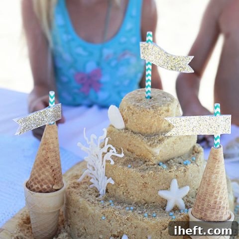 The final, beautifully decorated sandcastle cake, complete with flags, shells, and crumb coating.