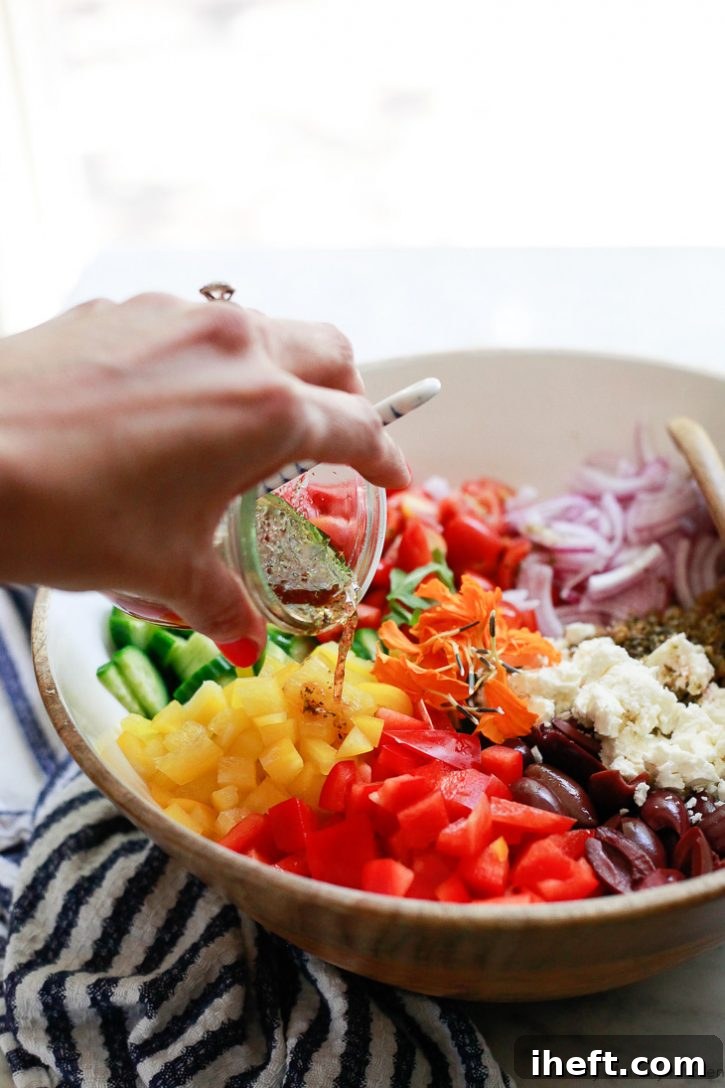 A Greek style red wine vinaigrette gets poured over a Mediterranean lentil salad with feta, cucumber, bell pepper, and olives. 