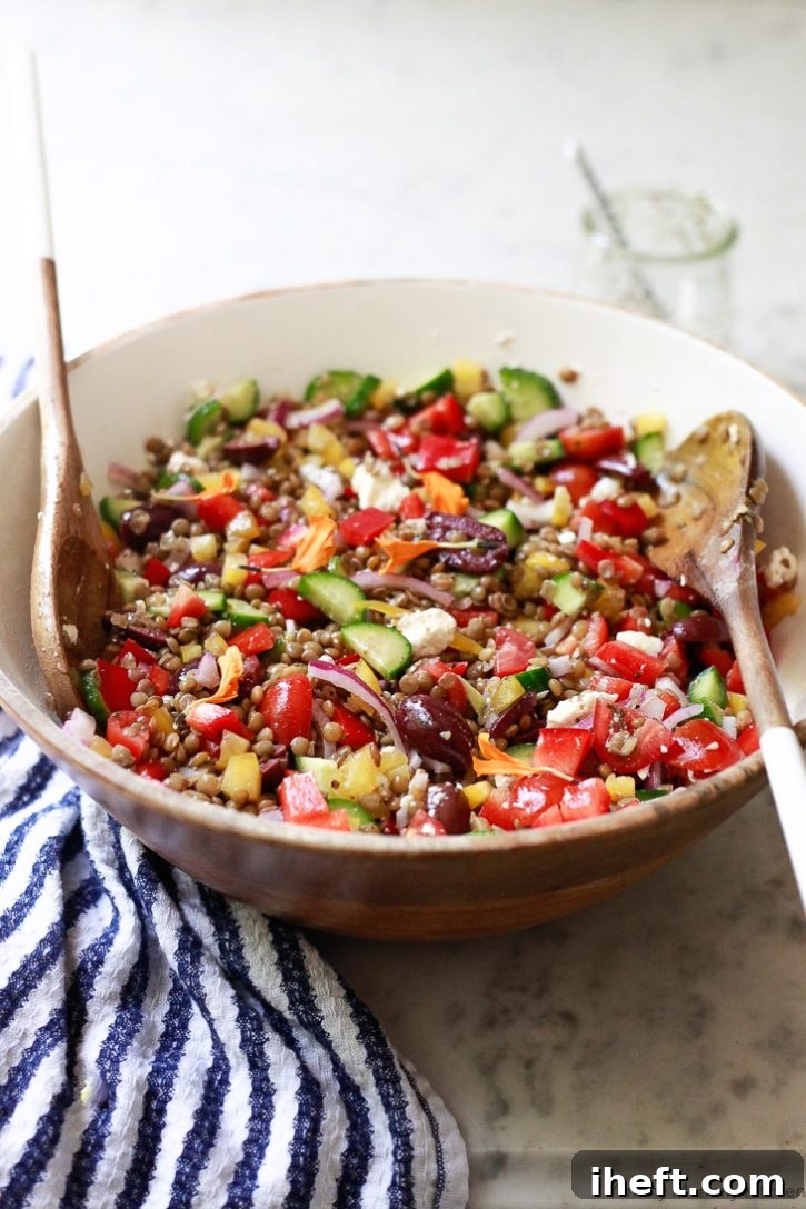 A delicious tossed Mediterranean lentil salad in a wooden salad bowl. This colorful lentil salad is naturally vegetarian or vegan. 