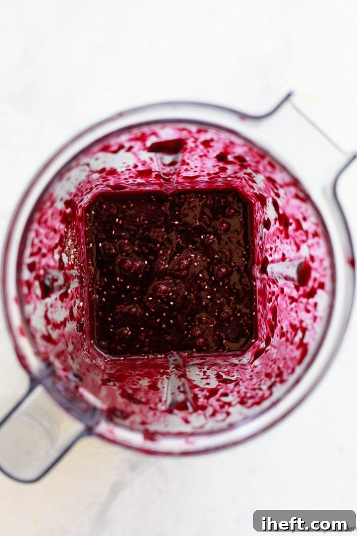 Blueberry chia jam being pureed to a smooth consistency in a Vitamix blender, ensuring a perfect texture for spreading.