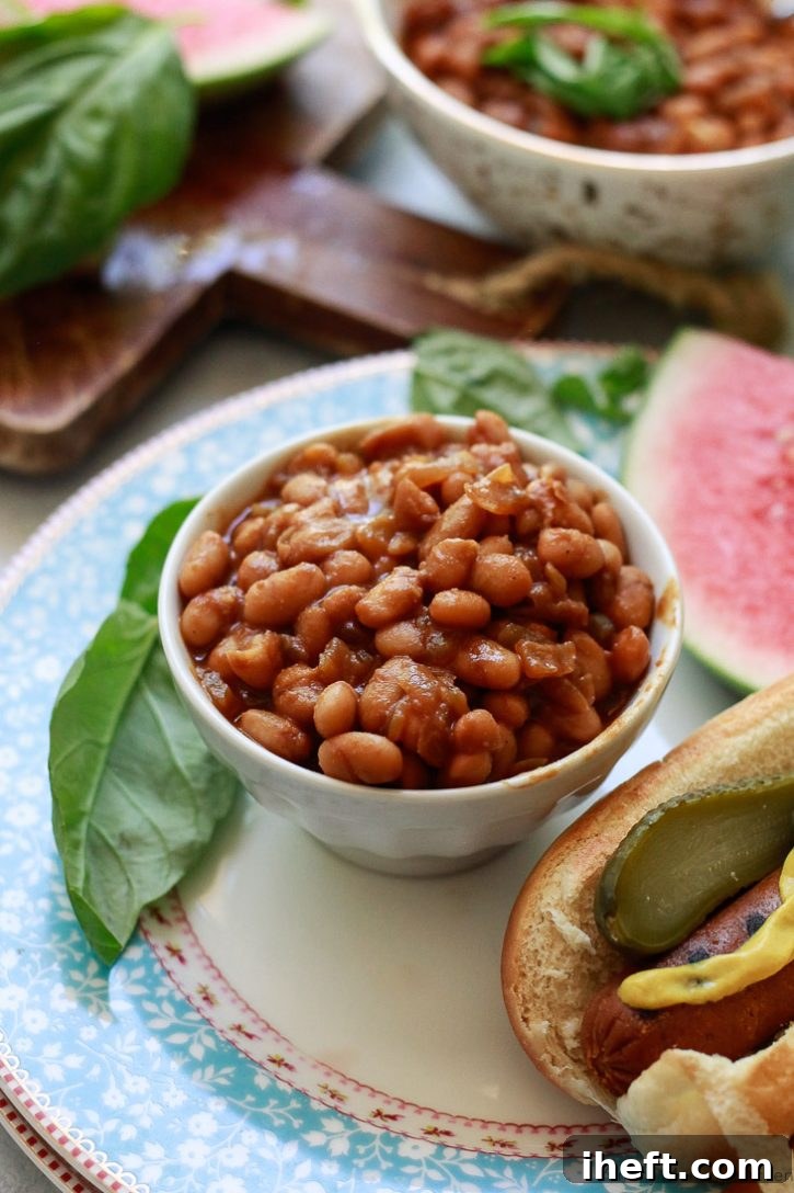 A vibrant bowl of homemade vegetarian baked beans, rich brown in color, garnished lightly. This easy vegetarian baked beans recipe is vegan and gluten-free, serving as an excellent dinner or BBQ side dish.