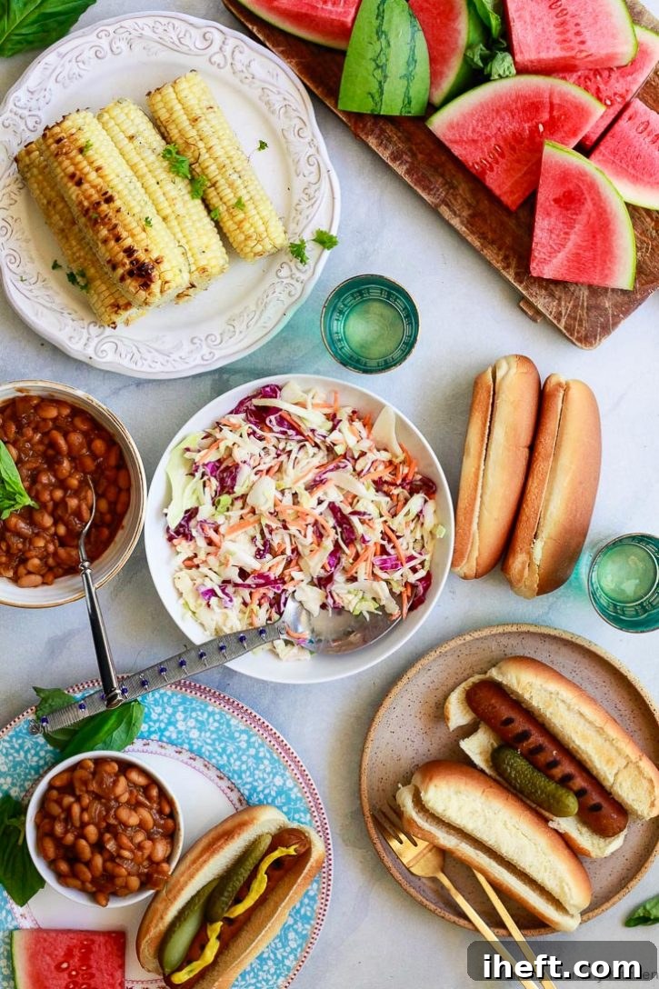 A vibrant vegetarian BBQ spread featuring grilled corn, juicy veggie hotdogs, refreshing vegan coleslaw, sweet watermelon slices, and savory baked beans, perfect for a summer gathering.