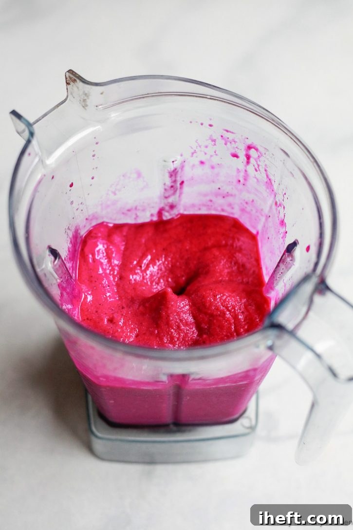 A bright red dragon fruit smoothie made in a Vitamix blender. 