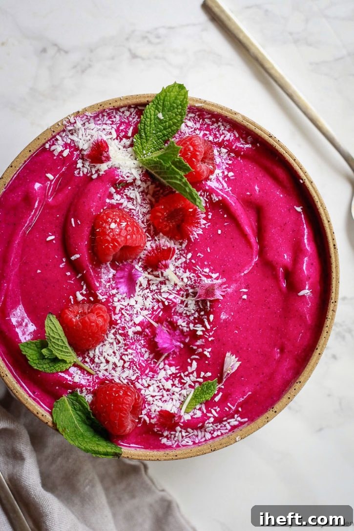 Bright pink dragon fruit smoothie bowl with coconut. This dragon fruit smoothie is made with banana, coconut, and mango. 